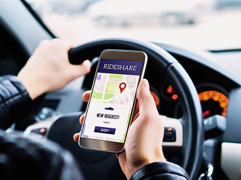 Ride share driver in car using the rideshare app in mobile phone. Rideshare and Self‑Driving Car Accident Claims